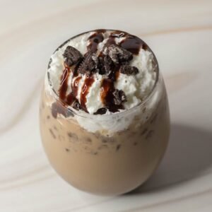 Close-up of a creamy chocolate Oreo milkshake topped with whipped cream and chocolate sauce.